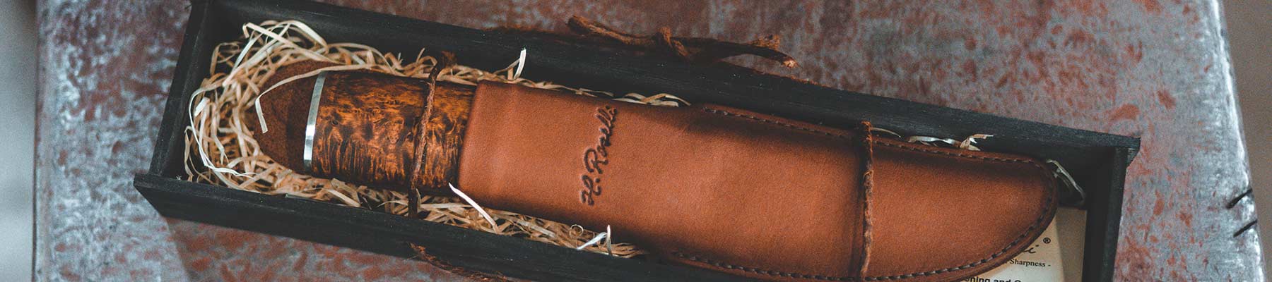 Roselli handmade knife in leather sheath laying in black gift box 