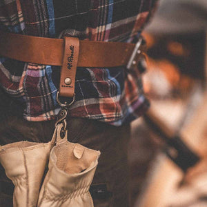 Picture represents Roselli's Finnish handmade belt loop sitting on a belt and wearing a pair of gloves.